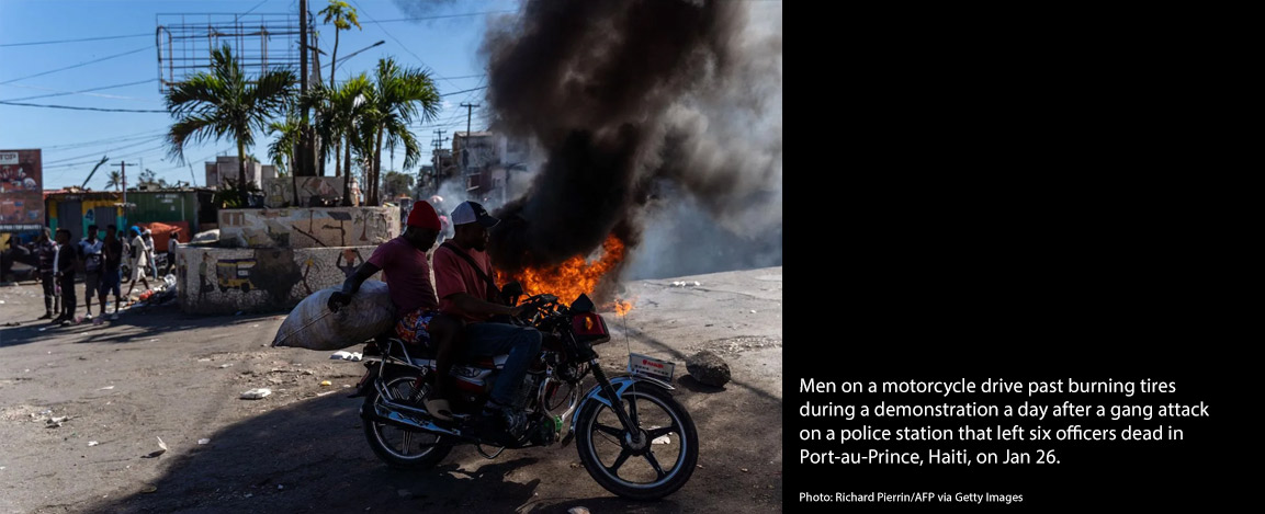 Men on motorcycles in front of burning tires